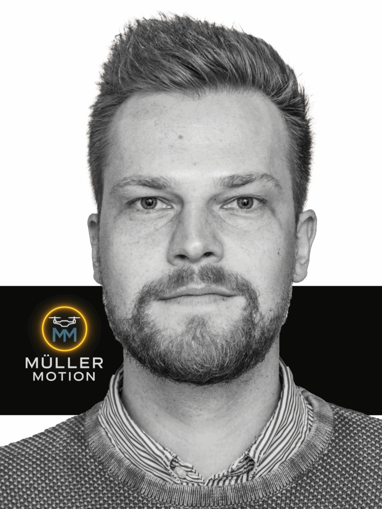 Eine Person mit einem Logo im Hintergrund. Auf dem Logo steht MÜLLER MOTION.